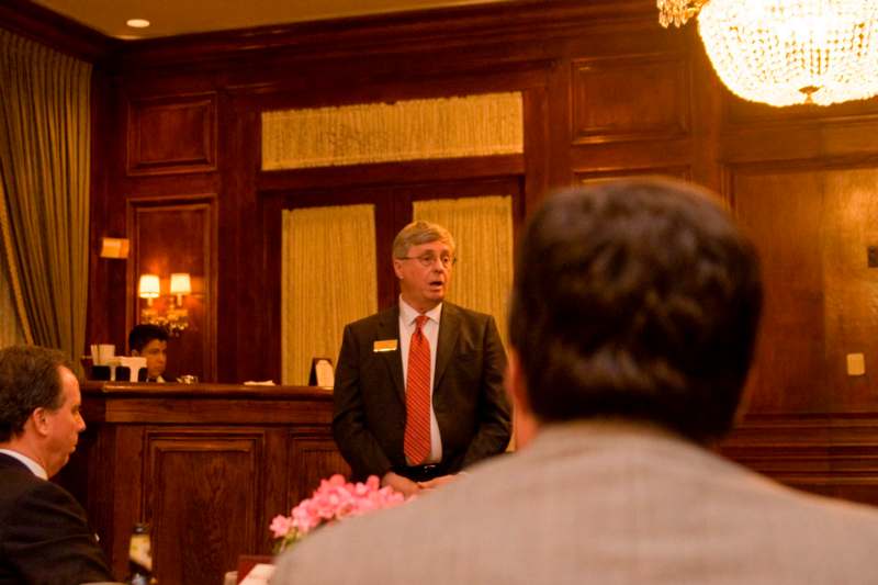 a man in a suit talking to a group of people