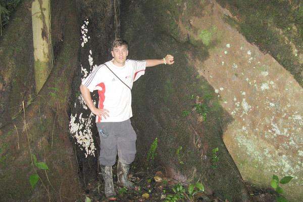 a man standing in front of a rock