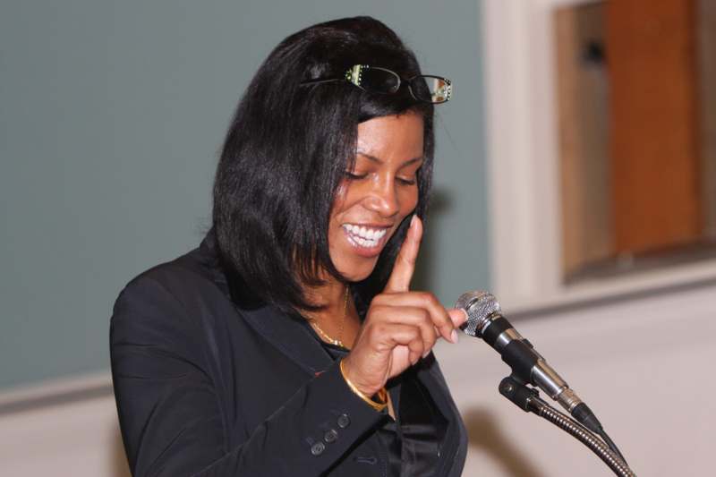 a woman smiling at a microphone