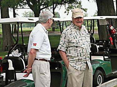 men standing next to a golf cart