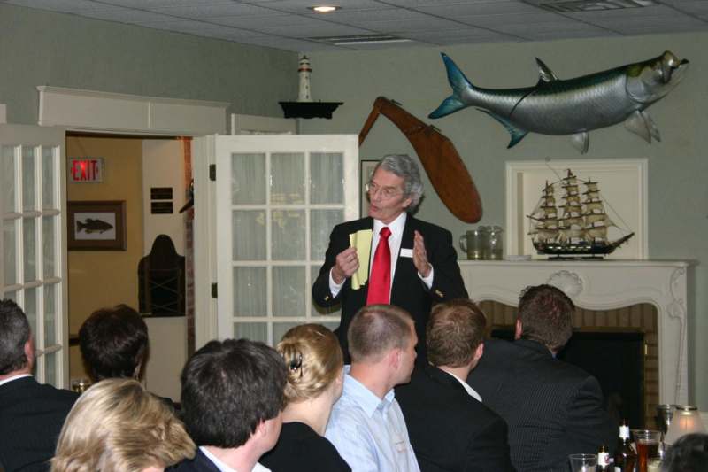 a man in a suit giving a presentation to a group of people