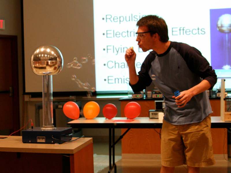 a man blowing bubbles in front of a projector