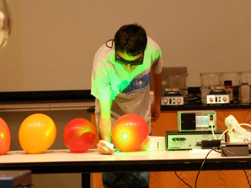 a man wearing goggles and holding a light up light up balloon