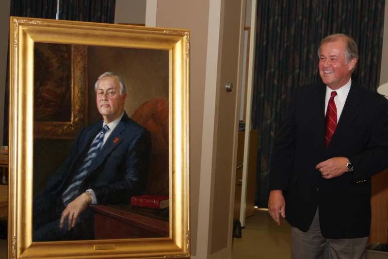 a man standing next to a painting of a man