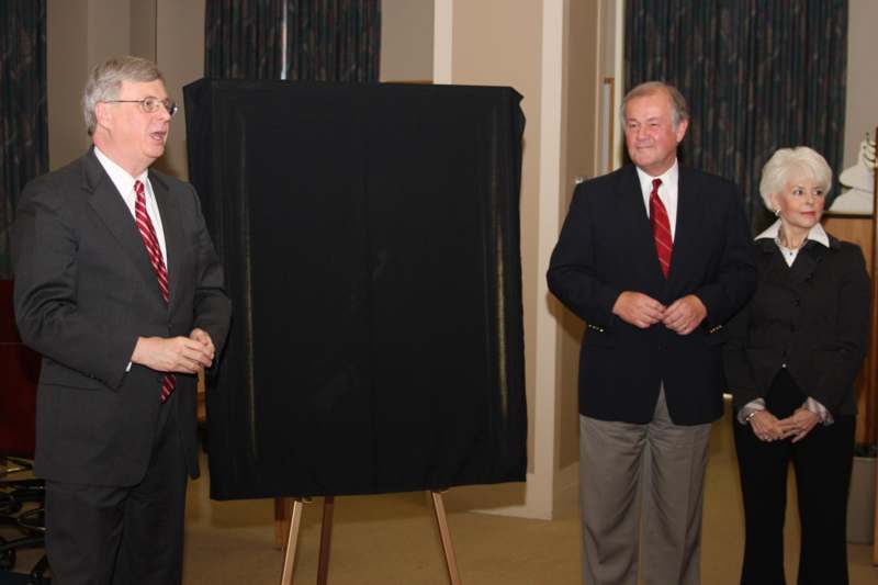 a group of men standing next to a black rectangular object