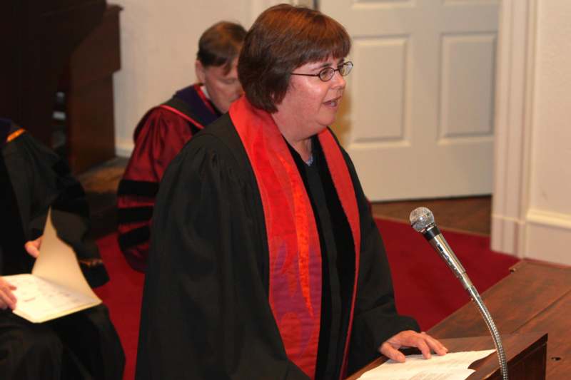 a woman in a robe standing at a podium