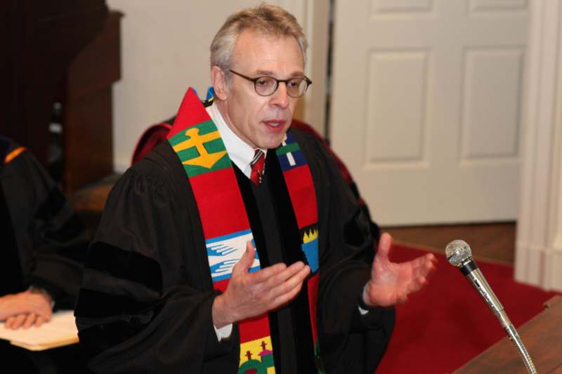 a man in a robe speaking into a microphone