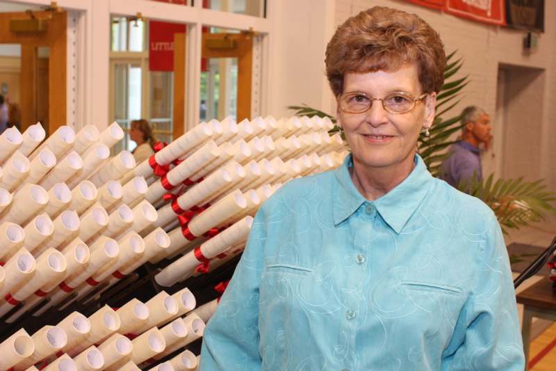 a woman standing in front of a bunch of white rolled up paper