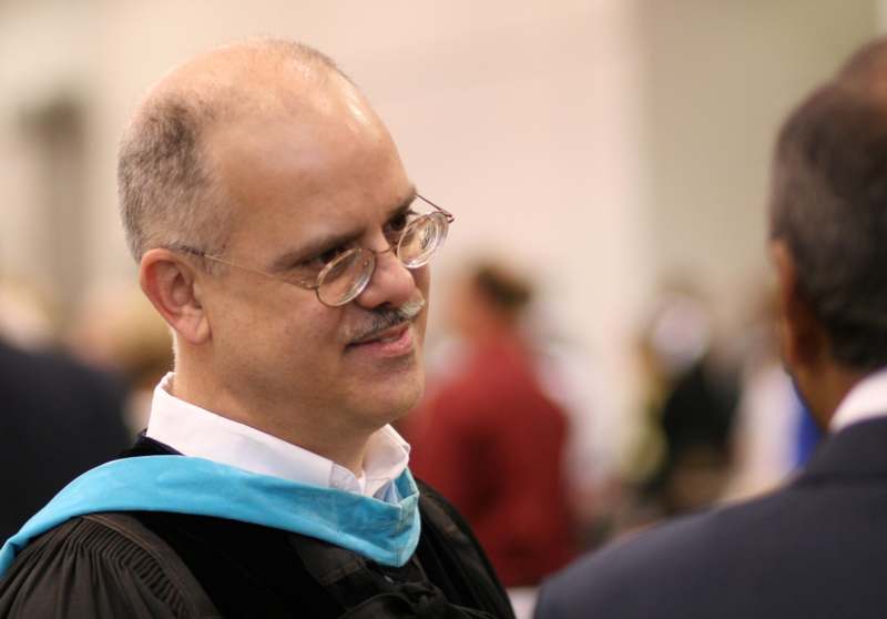 a man wearing glasses and a graduation cap
