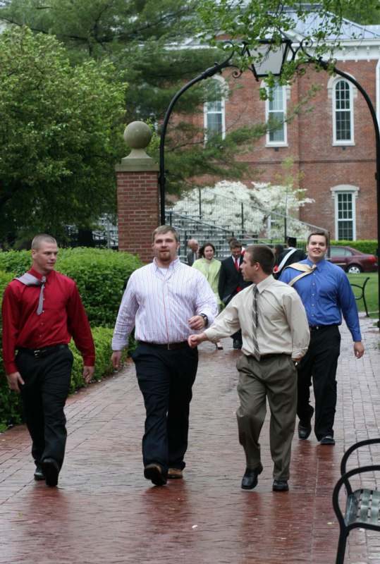 a group of men walking down a brick path