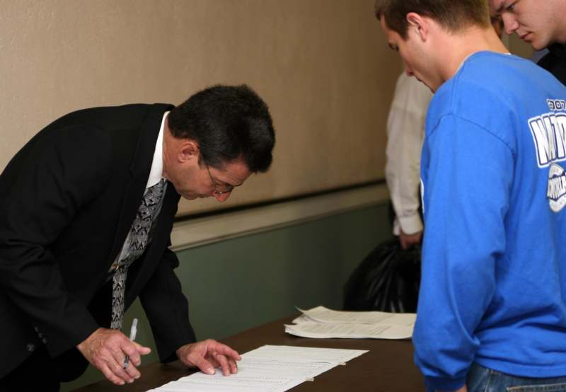 a man signing papers on a table