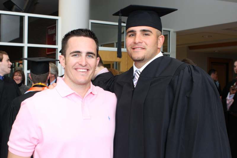 a man in a cap and gown posing with another man