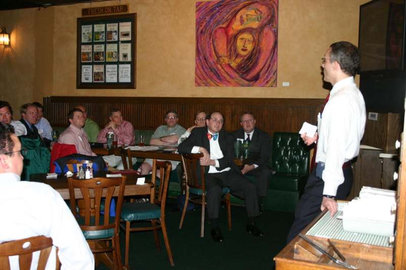 a man standing in front of a group of people sitting at tables