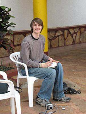 a man sitting on a white plastic chair