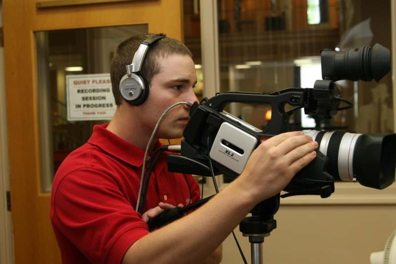 a man with headphones using a video camera