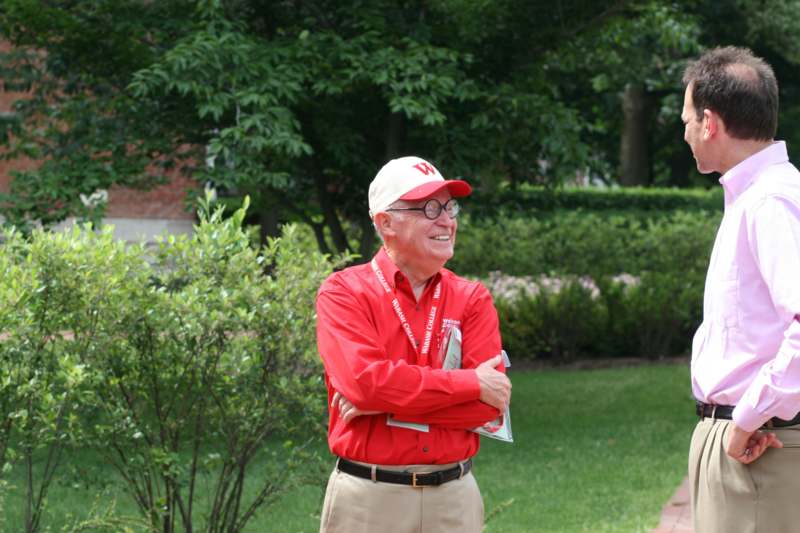 a man in red shirt and hat with arms crossed
