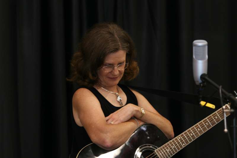 a woman with her arms crossed and a guitar
