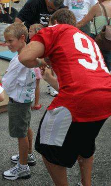 a woman in a red jersey with a boy in the background