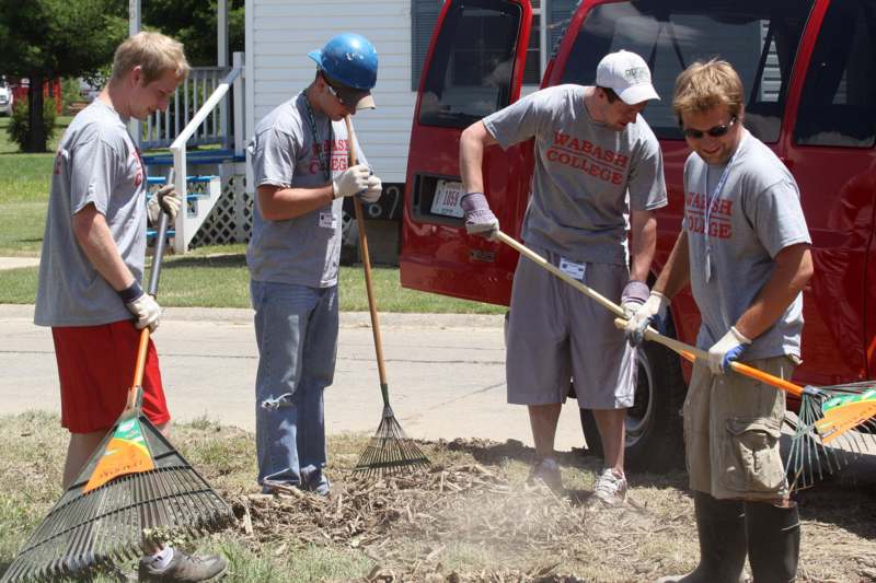 a group of people raking the ground