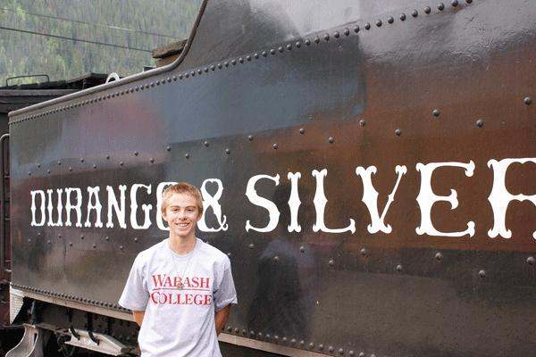 a boy standing in front of a train