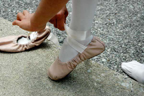 a person tying a ballet slipper