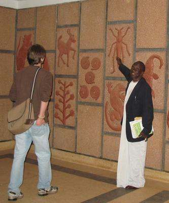 a man pointing at a wall with a picture
