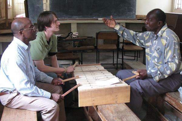 a group of people sitting around a xylophone