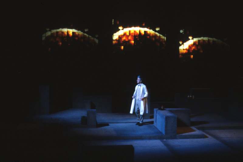 a man in a white coat on a stage