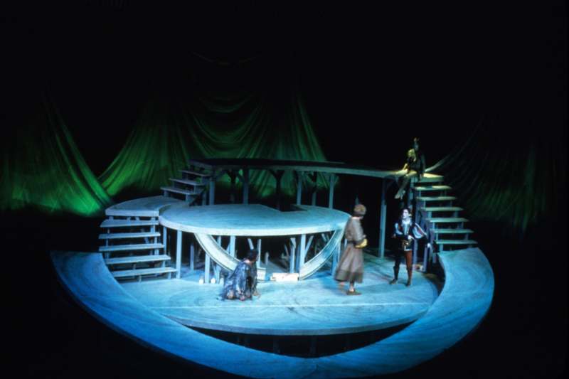a stage with a round wooden structure with people on it