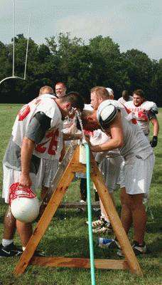 a group of football players pouring water from a ladder