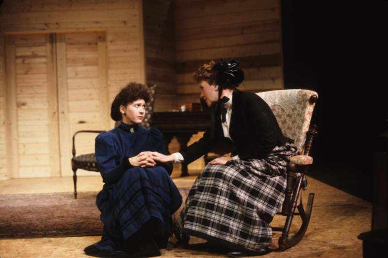 a woman sitting in a rocking chair and another woman sitting in a chair