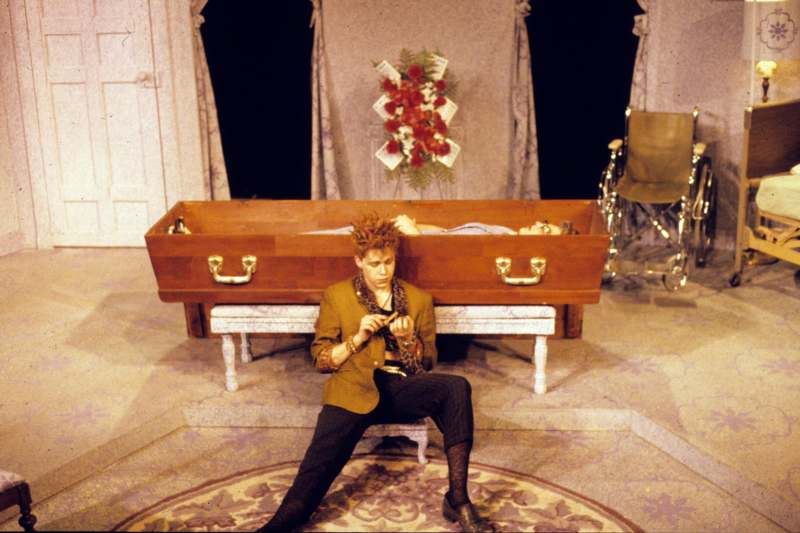 a man sitting on a bench in a coffin