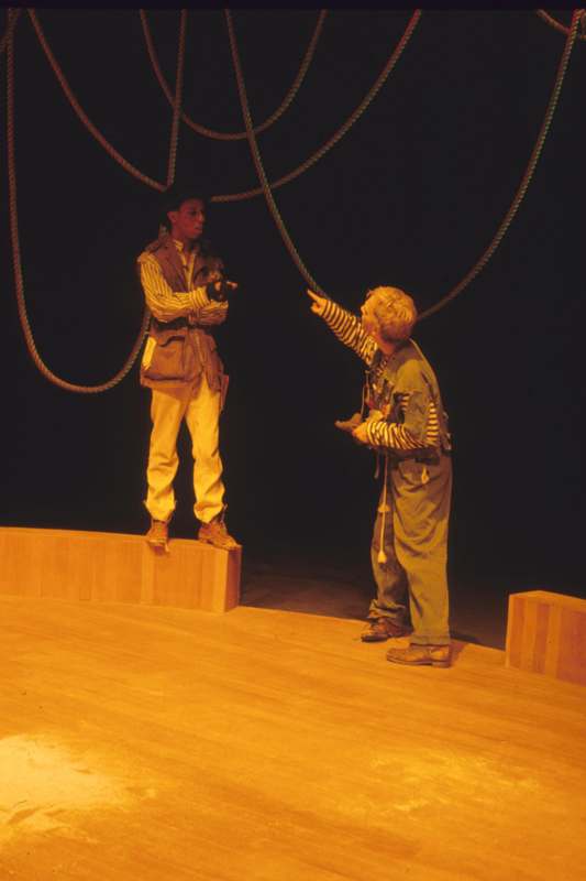 a man standing on a stage with a man pointing at another man