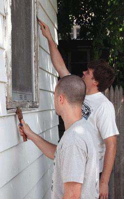 a couple of men painting a house