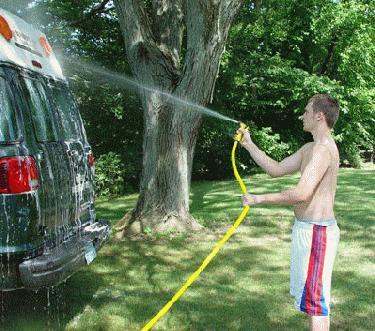 a man spraying water on a van
