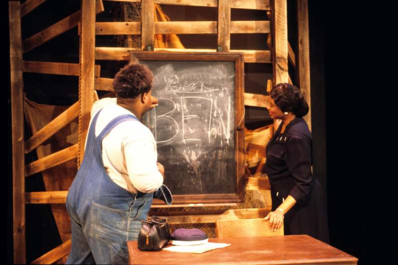 a man and woman standing next to a chalkboard