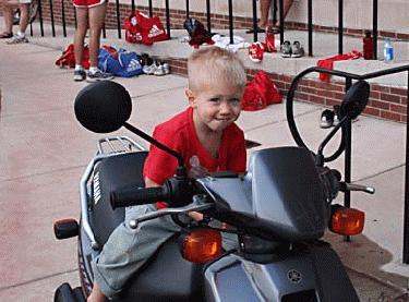 a boy sitting on a motorcycle