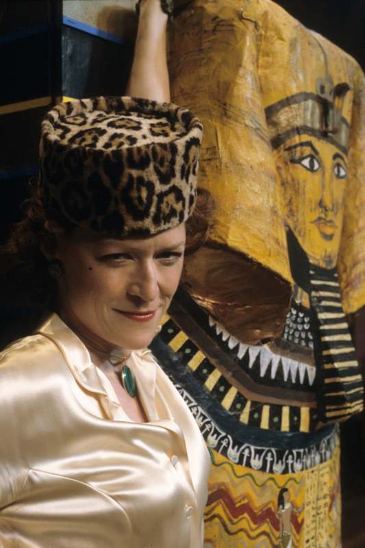 a woman in a white blouse and leopard print hat