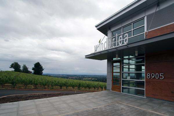 a building with a vineyard in the background
