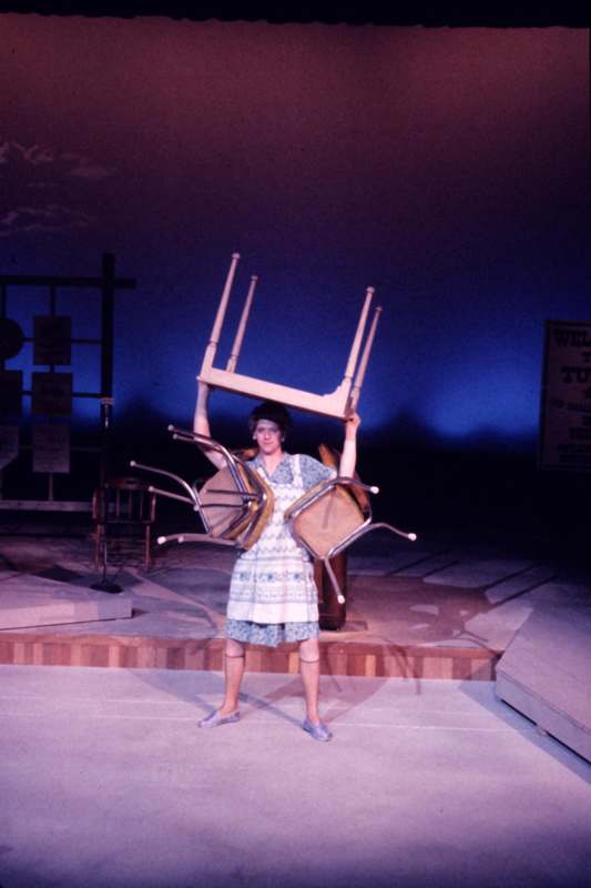 a woman holding a chair over her head