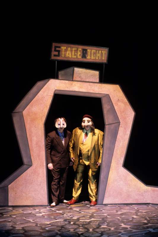 two men in clothing standing in a stage