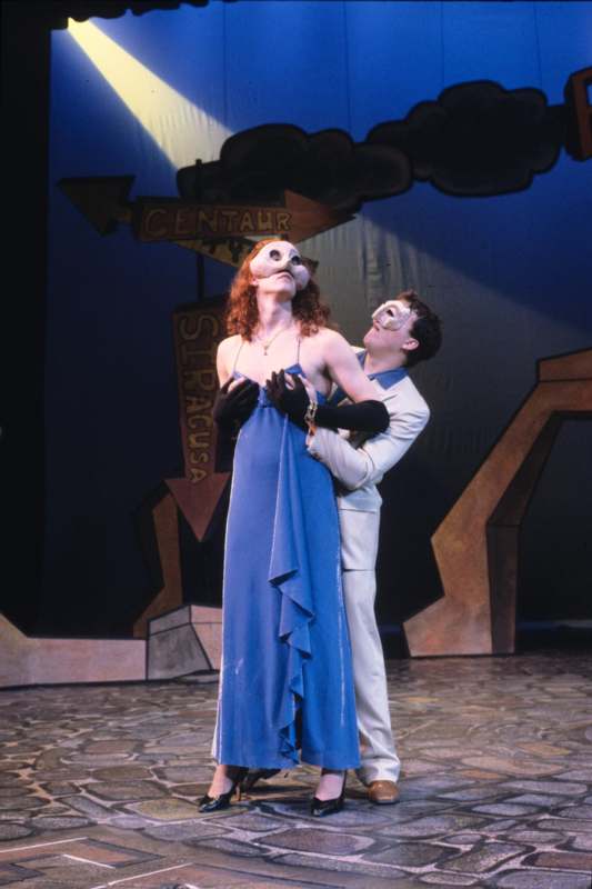 a man and woman in a blue dress and mask