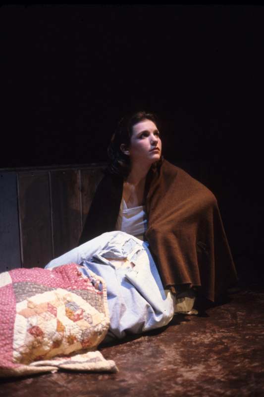 a woman sitting on the floor with a blanket