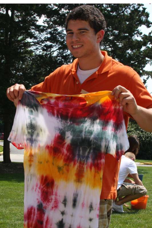 a man holding a tie dye shirt