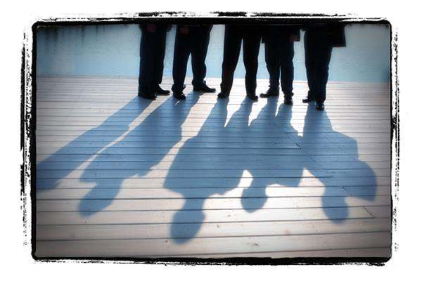 shadows of people standing on a wooden surface