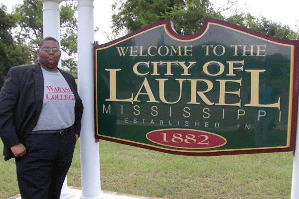 a man standing next to a sign