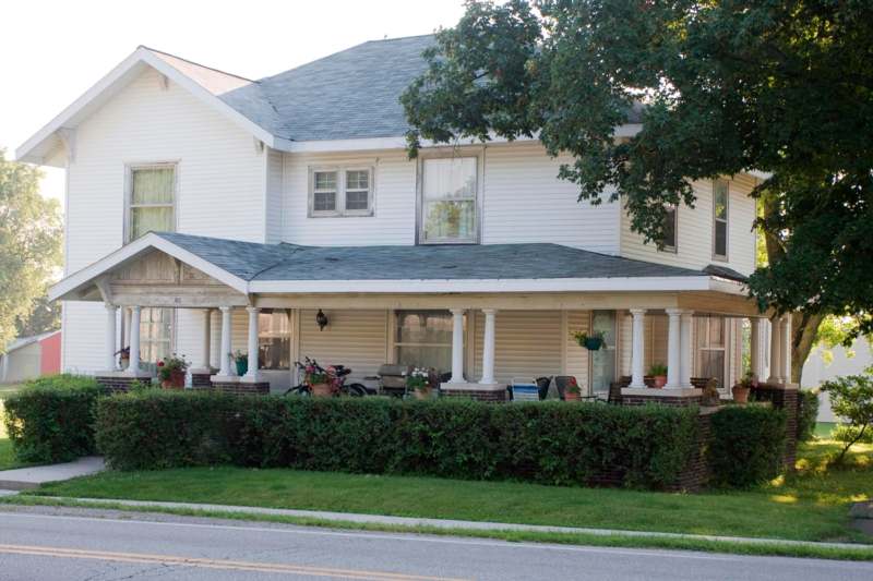 a house with a large porch and a hedge