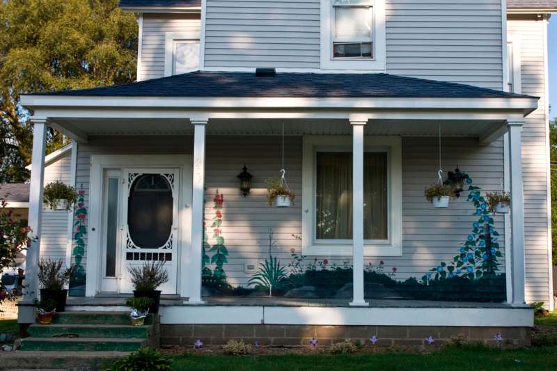 a house with a porch and a porch with plants on it