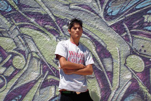 a man standing in front of a wall with his arms crossed