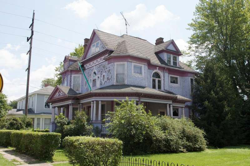a house with a fence and bushes